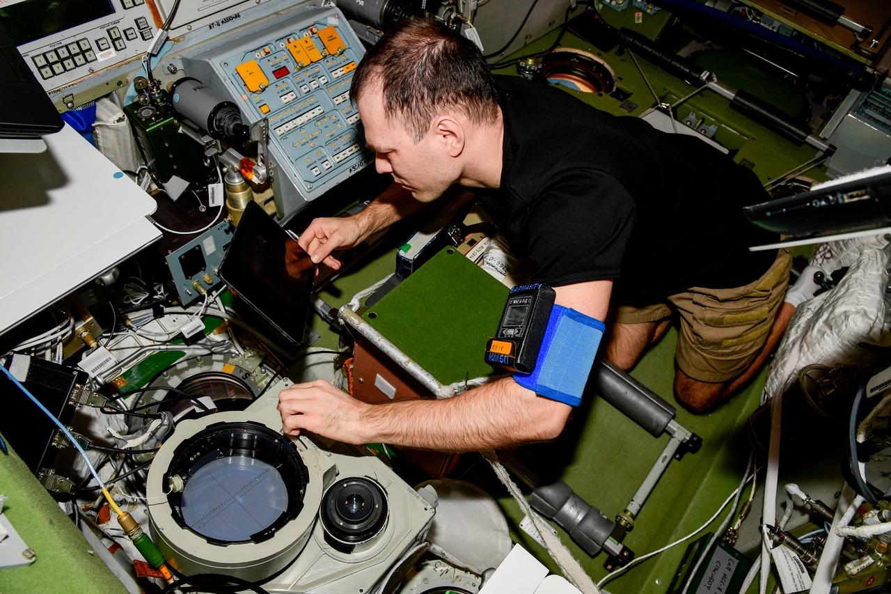 iss068e040003 (Jan. 11, 2023) --- Roscosmos cosmonaut and Expedition 68 Flight Engineer Dmitri Petelin configures optical hardware inside the International Space Station's Zvezda service module. Credit: Roscosmos