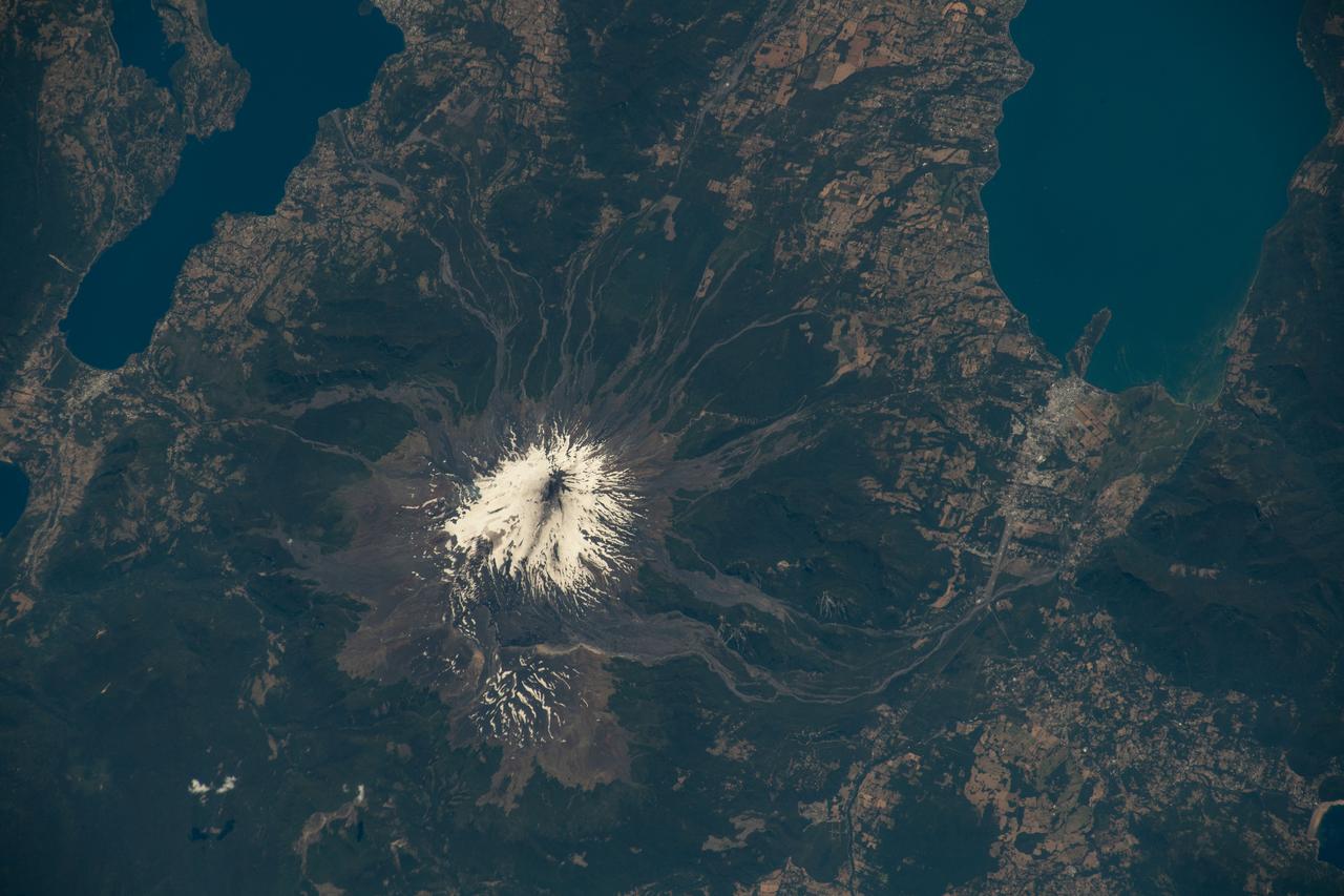 iss068e040596 (Jan. 17, 2023) --- Chile’s Villarrica volcano emits steam and other volcanic gases in this photo taken from the International Space Station on Jan. 17, 2023. The gases come from a series of minor explosions—called Strombolian eruptions—that have been ongoing at Villarrica since October 2022. Located along Chile’s southern Andes, Villarrica is one of the most active and dangerous volcanoes in South America; it typically erupts every three to six years. Image Credit: NASA
