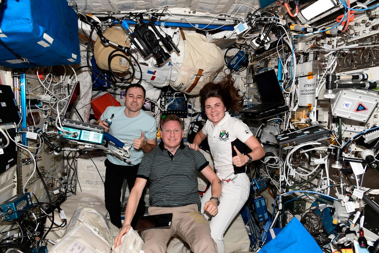 iss068e042986 (Jan. 26, 2023) --- Expedition 68 Commander Sergey Prokopyev (foreground) with Flight Engineers Dmitri Petelin and Anna Kikina, all three Roscosmos cosmonauts, pose for a portrait inside the International Space Station's Columbus laboratory module. Credit: Roscosmos