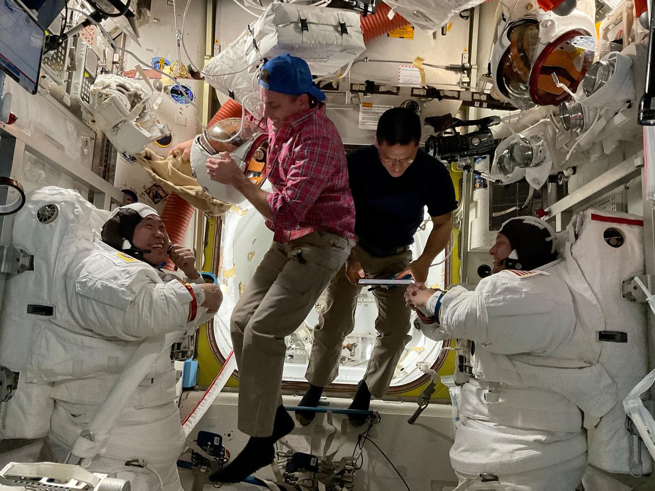 iss068e054809 (Feb. 2, 2023) ---  (At far left and right) Astronauts Koichi Wakata of JAXA (Japan Aerospace Exploration Agency) and Nicole Mann of NASA are suited up in their Extravehicular Mobility Units (EMUs), or spacesuits, following a spacewalk on Feb. 2, 2023, to install hardware on the International Space Station's Port-6 truss structure. Assisting the duo out of their EMUs are NASA Flight Engineers (center left and right) Josh Cassada and Frank Rubio.