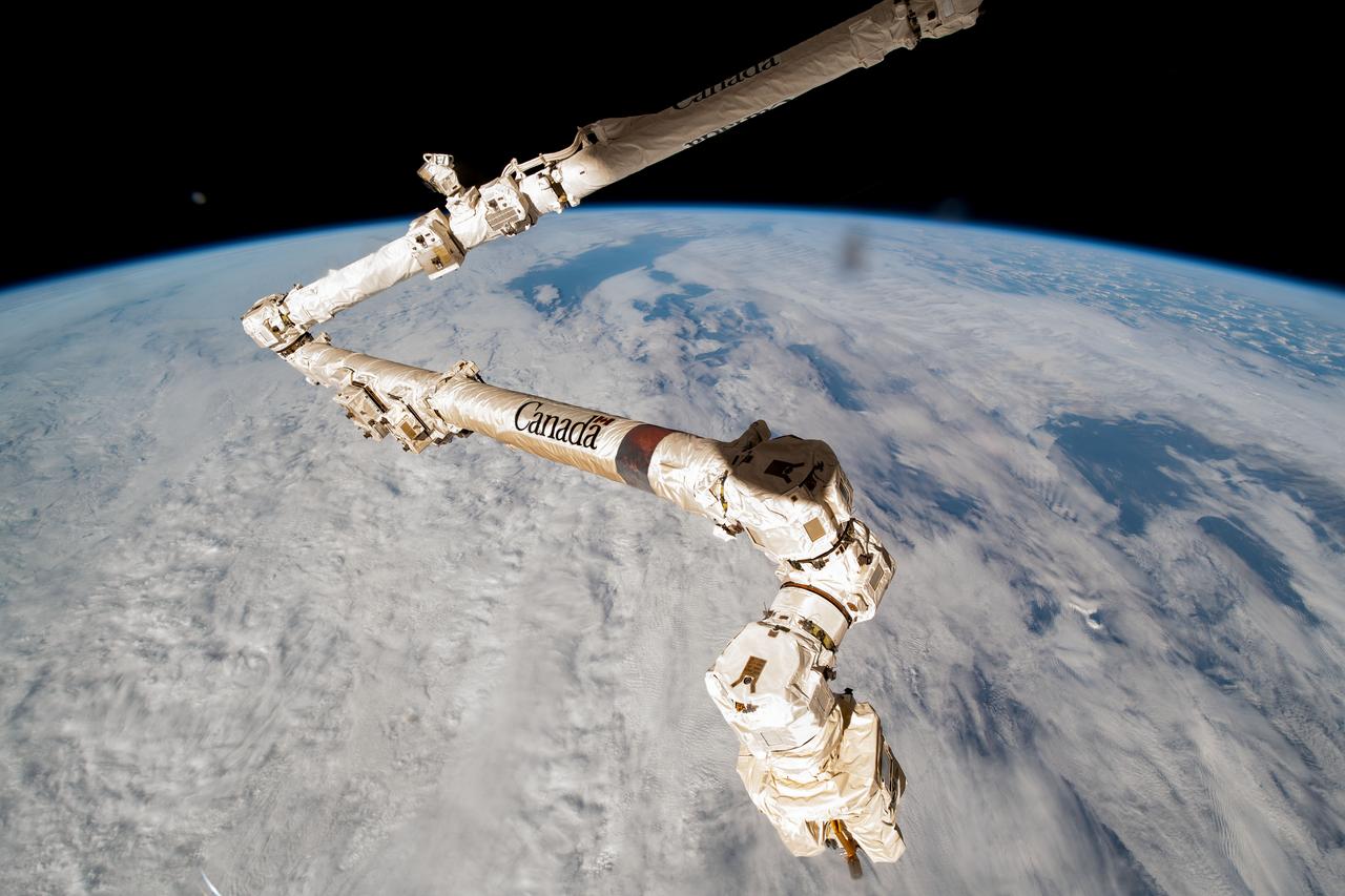 iss068e071305 (March 6, 2023) --- The Canadarm2 robotic arm extends from the International Space Station as it orbited 258 miles above a cloudy East China Sea off the coast of Shanghai, China's largest city.