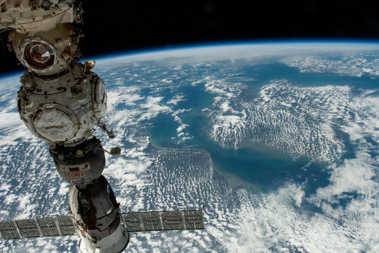 iss069e003171 (April 13, 2023) --- Three Roscosmos components on the International Space Station were photographed by UAE (United Arab Emirates) astronaut and Expedition 69 Flight Engineer Sultan Alneyadi while orbiting 263 miles above a partly cloudy northern Europe. At left, from top to bottom, are the Nauka multipurpose laboratory module's forward port, the Prichal docking module, and the Soyuz MS-23 crew ship.