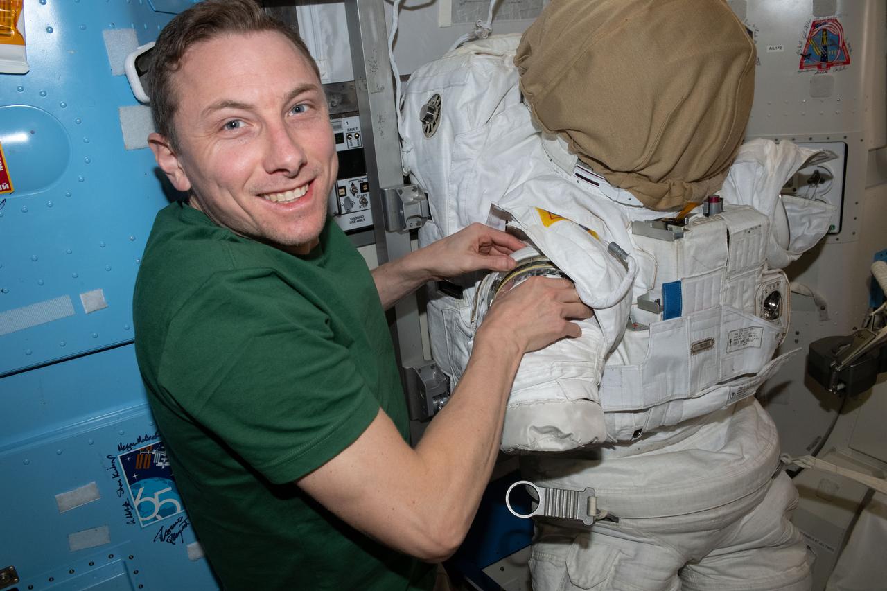 iss069e003918 (April 17, 2023) --- NASA astronaut and Expedition 69 Flight Engineer Woody Hoburg prepares an Extravehicular Mobility Unit, or spacesuit, inside the International Space Station's Quest airlock for an upcoming spacewalk.