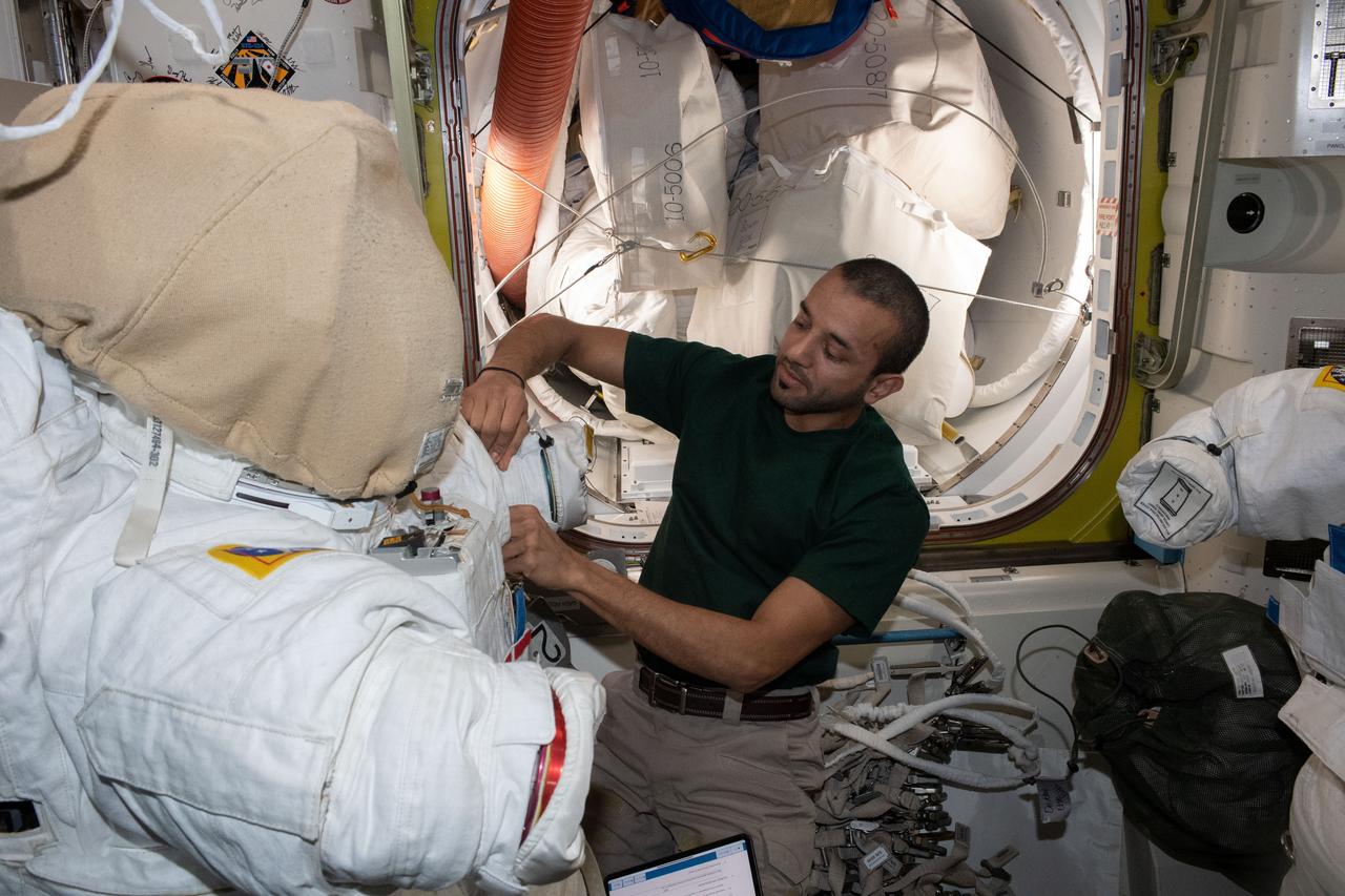 iss069e003933 (April 17, 2023) --- UAE (United Arab Emirates) astronaut and Expedition 69 Flight Engineer Sultan Alneyadi prepares an Extravehicular Mobility Unit, or spacesuit, inside the International Space Station's Quest airlock for an upcoming spacewalk.