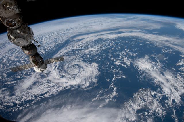 NASA image: The space station orbits above a partly cloudy Pacific Ocean