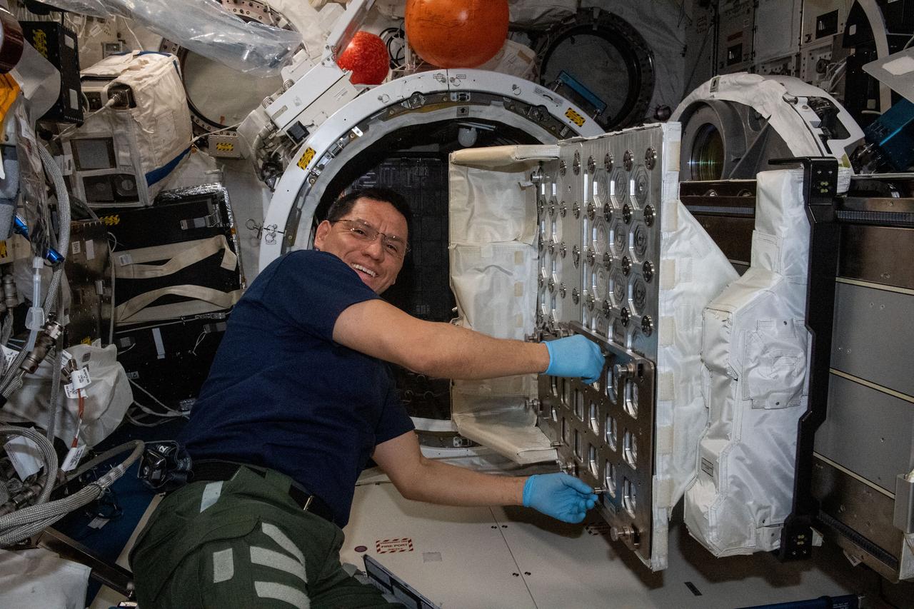 iss069e004389 (April 20, 2023) --- NASA astronaut and Expedition 69 Flight Engineer Frank Rubio works to install the NanoRacks CubeSat Deployer inside the Kibo laboratory module's airlock. After the airlock is depressurized, the Japanese robotic arm grapples the deployer and places it outside in the vacuum of microgravity pointing it away from the International Space Station. CubeSats from private, governmental, and academic organizations are then deployed into Earth orbit for a variety of research objectives.