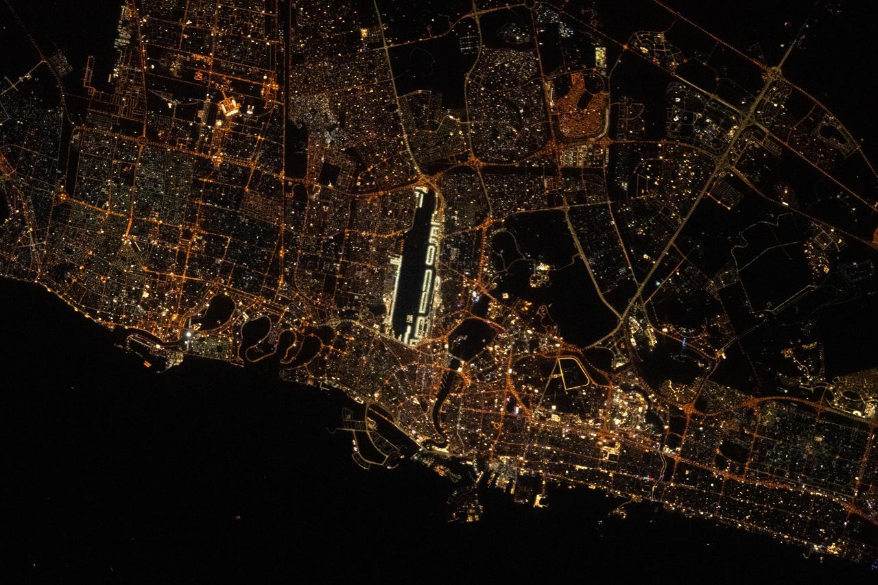 iss069e005018 (April 23, 2023) --- The city lights of Sharjah and Dubai in the United Arab Emirates, with Dubai International Airport (center) next to the Ras Al Khor Wildlife Sanctuary (dark area), are pictured from the International Space Station as it orbited 262 miles above.