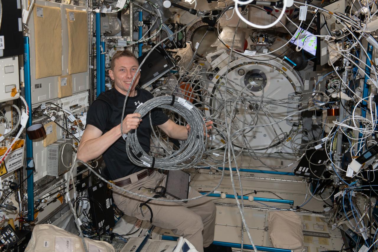 iss069e005419 (April 26, 2023) --- NASA astronaut and Expedition 69 Flight Engineer Woody Hoburg reconfigures video cables belonging to the Kibo laboratory module's Cell Biology Experiment Facility, a research incubator that generates artificial gravity.