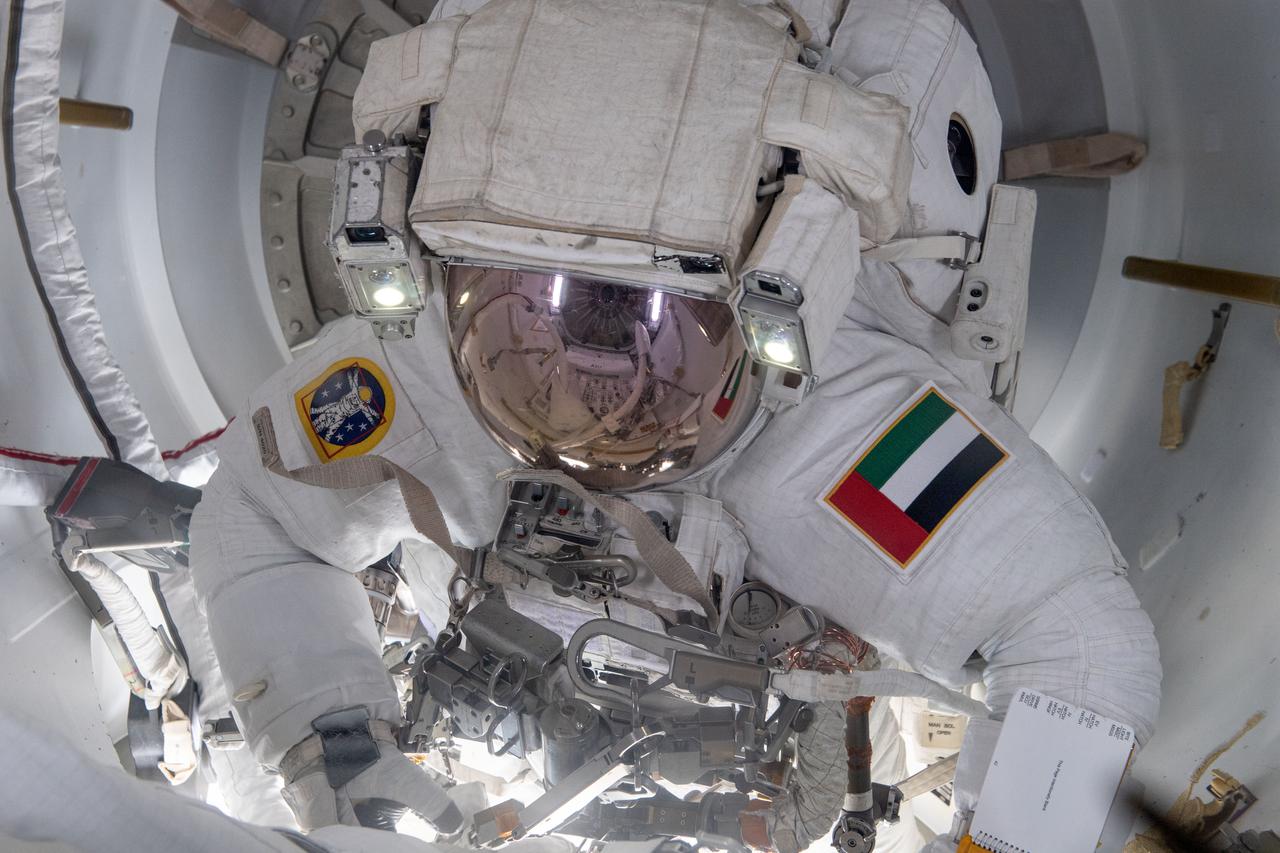 iss069e005717 (April 28, 2023) --- UAE (United Arab Emirates) astronaut and Expedition 69 Flight Engineer Sultan Alneyadi is pictured in his Extravehicular Mobility Unit, or spacesuit, preparing to exit the International Space Station's Quest airlock and begin his first spacewalk. He and NASA astronaut Stephen Bowen (out of frame) would spend seven hours and one minute in the vacuum of space routing cables and installing insulation readying the orbital outpost for its next set of roll-out solar arrays due to be installed after their delivery on the next SpaceX Dragon cargo mission.
