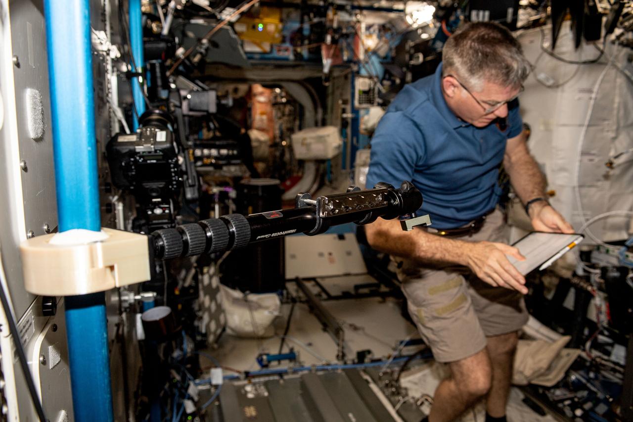 iss069e009786 (May 9, 2023) --- NASA astronaut and Expedition 69 Flight Engineer Stephen Bowen installs student-made hardware next to the Destiny laboratory module's Microgravity Science Glovebox. The High school students United with NASA to Create Hardware (HUNCH) Ball Clamp Monopod (HUNCH Ball Clamp Monopod) investigation tests a platform for holding cameras used to track targets on the ground or take images and video within space station modules