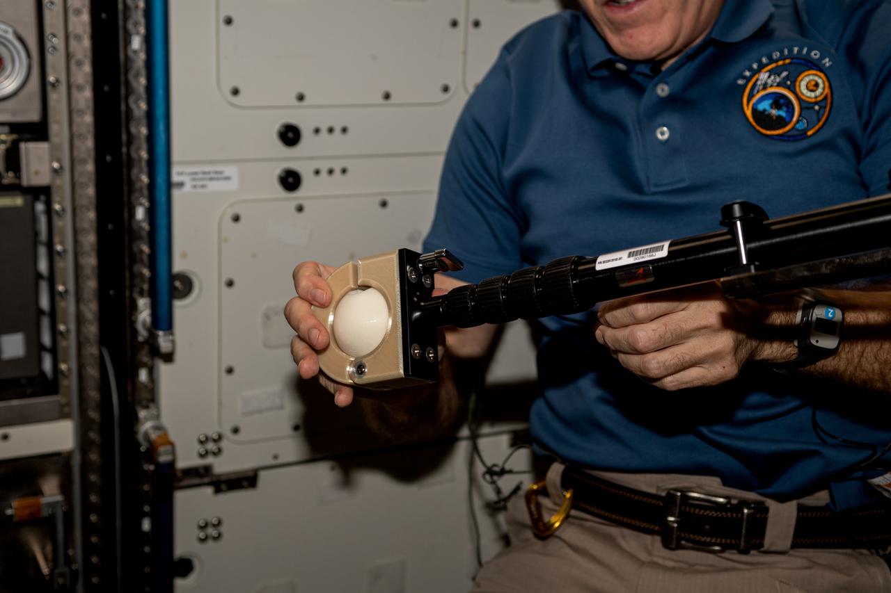 iss069e009795 (May 9, 2023) --- NASA astronaut and Expedition 69 Flight Engineer Stephen Bowen installs student-made hardware next to the Destiny laboratory module's Microgravity Science Glovebox. The High school students United with NASA to Create Hardware (HUNCH) Ball Clamp Monopod (HUNCH Ball Clamp Monopod) investigation tests a platform for holding cameras used to track targets on the ground or take images and video within space station modules