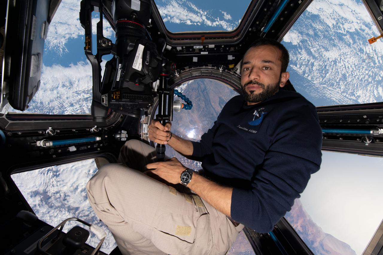 iss069e010671 (May 14, 2023) --- UAE (United Arab Emirates) astronaut and Expedition 69 Flight Engineer Sultan Alneyadi is pictured with camera gear inside the seven window cupola as the International Space Station orbited 263 miles above Cape Town, South Africa.