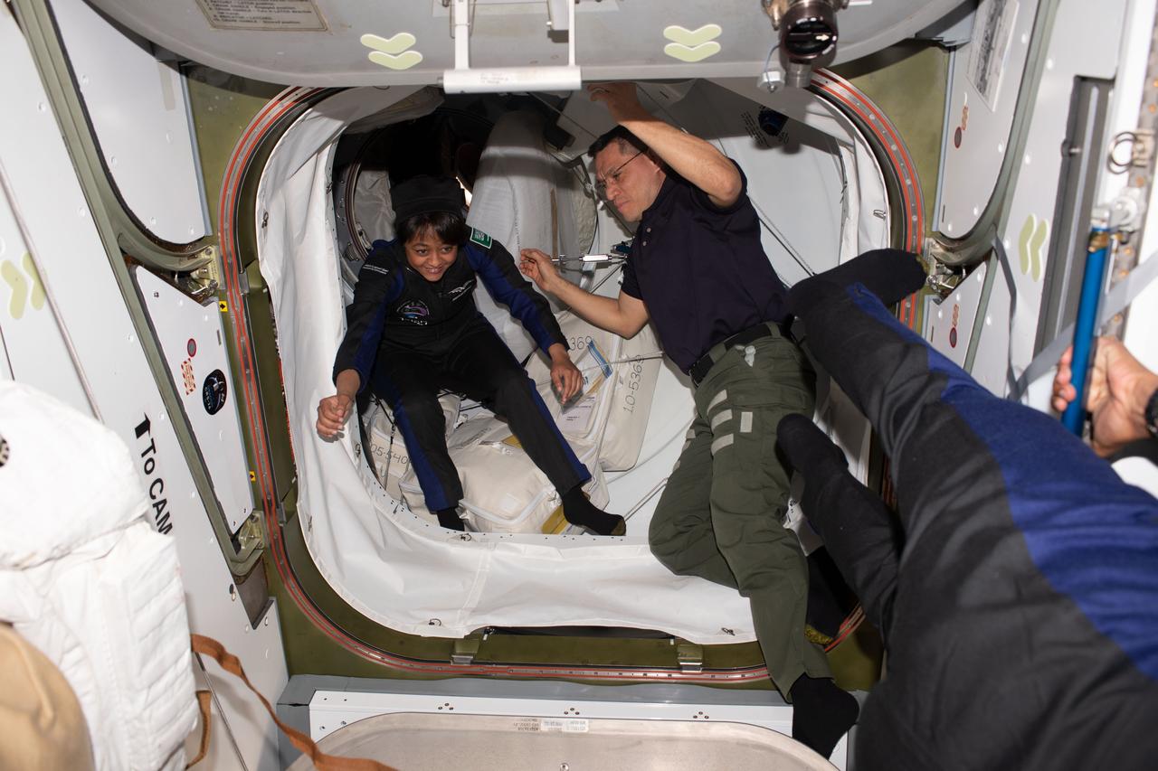 iss069e013999 (May 22, 2023) --- Axiom Space private astronaut and Axiom Mission-2 Mission Specialist Rayyanah Barnawi enters the International Space Station shortly after the hatches were opened between the orbital outpost and the SpaceX Dragon Freedom spacecraft. Welcoming her inside the vestibule between the station's Harmony module and Dragon is NASA astronaut and Expedition 69 Flight Engineer Frank Rubio.