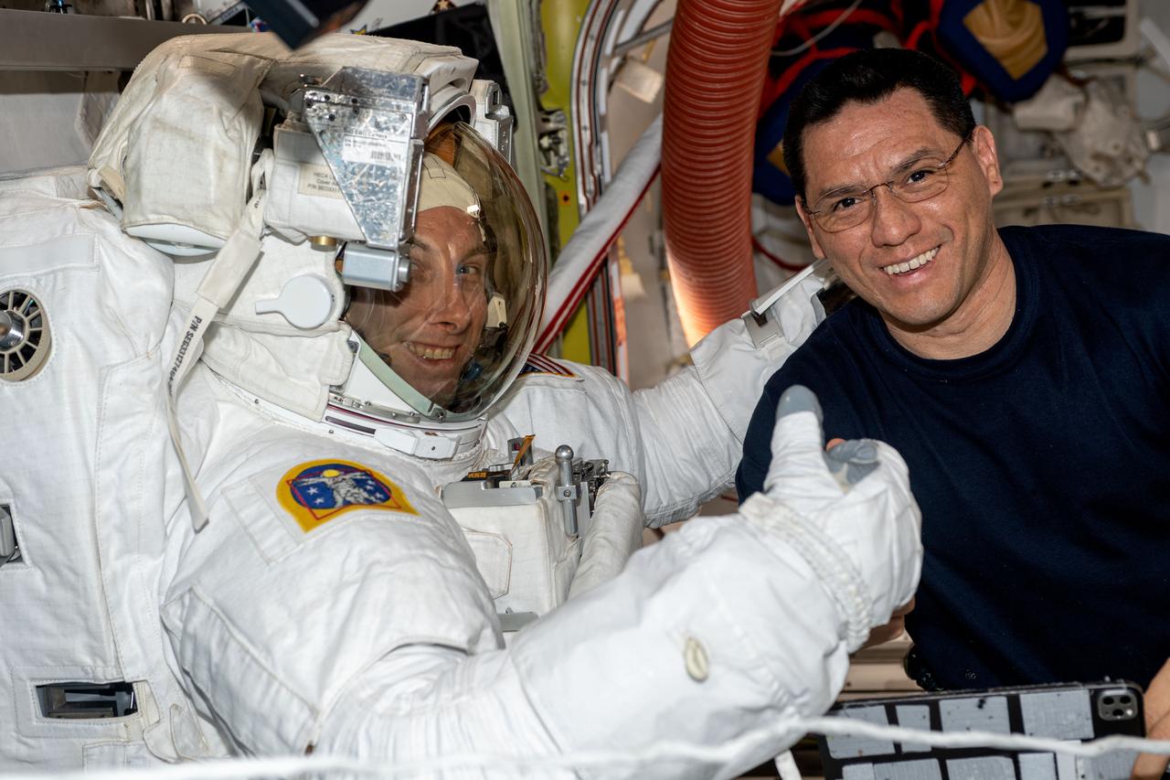 iss069e017126 (June 2, 2023) --- NASA astronaut Frank Rubio (right) assists NASA astronaut Woody Hoburg during a fit check of his spacesuit inside the International Space Station's Quest airlock.