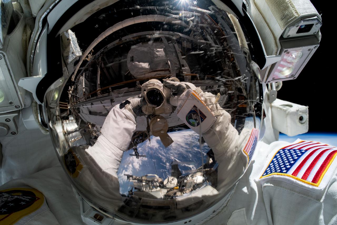 iss069e018575 (June 9, 2023) --- NASA astronaut and Expedition 68 Flight Engineer Woody Hoburg points the camera toward himself and takes an out-of-this-world "space-selfie" during a six-hour and three-minute spacewalk to install a roll-out solar array on the International Space Station's truss structure.