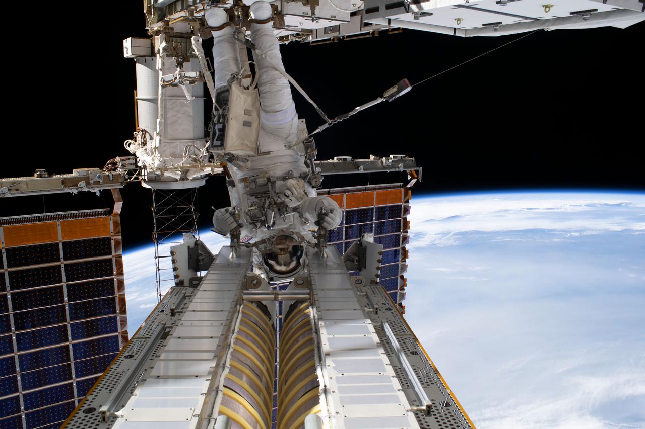 iss069e020618 (June 15, 2023) --- NASA astronaut Stephen Bowen is pictured during a spacewalk to install and deploy a roll-out solar array on the International Space Station. Bowen is attached to the Canadarm2 robotic arm during the removal of the roll-out solar array from a pallet before maneuvering it to the installation point on the Starboard-6 truss structure.