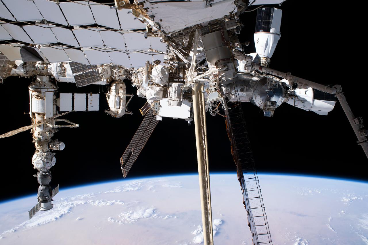 iss069e020780 (June 15, 2023) --- This view of the International Space Station was taken by NASA astronaut Stephen Hoburg as he worked on the Starboard-6 truss structure during a spacewalk. From left to right, major elements of the orbital outpost pictured include the Soyuz MS-23 crew ship docked to the Prichal docking module which is itself attached to Nauka science module; the Rassvet module attached to the Zarya module; the SpaceX Dragon cargo vehicle docked to the Harmony module's space-facing port; and the SpaceX Dragon crew vehicle docked to Harmony's forward port.