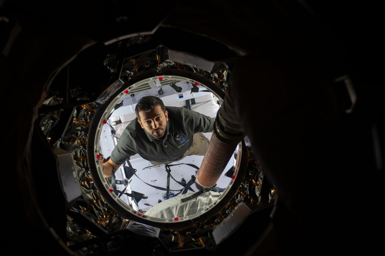 iss069e024858 (June 23, 2023) --- UAE (United Arab Emirates) astronaut and Expedition 69 Flight Engineer Sultan Alneyadi peers into the International Space Station while working inside the SpaceX Dragon cargo spacecraft.