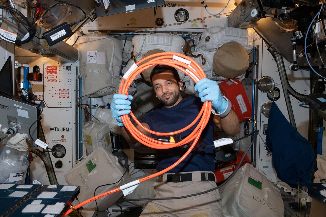 iss069e024882 (June 24, 2023) --- UAE (United Arab Emirates) astronaut and Expedition 69 Flight Engineer Sultan Alneyadi organizes cables inside the International Space Station's Harmony module.