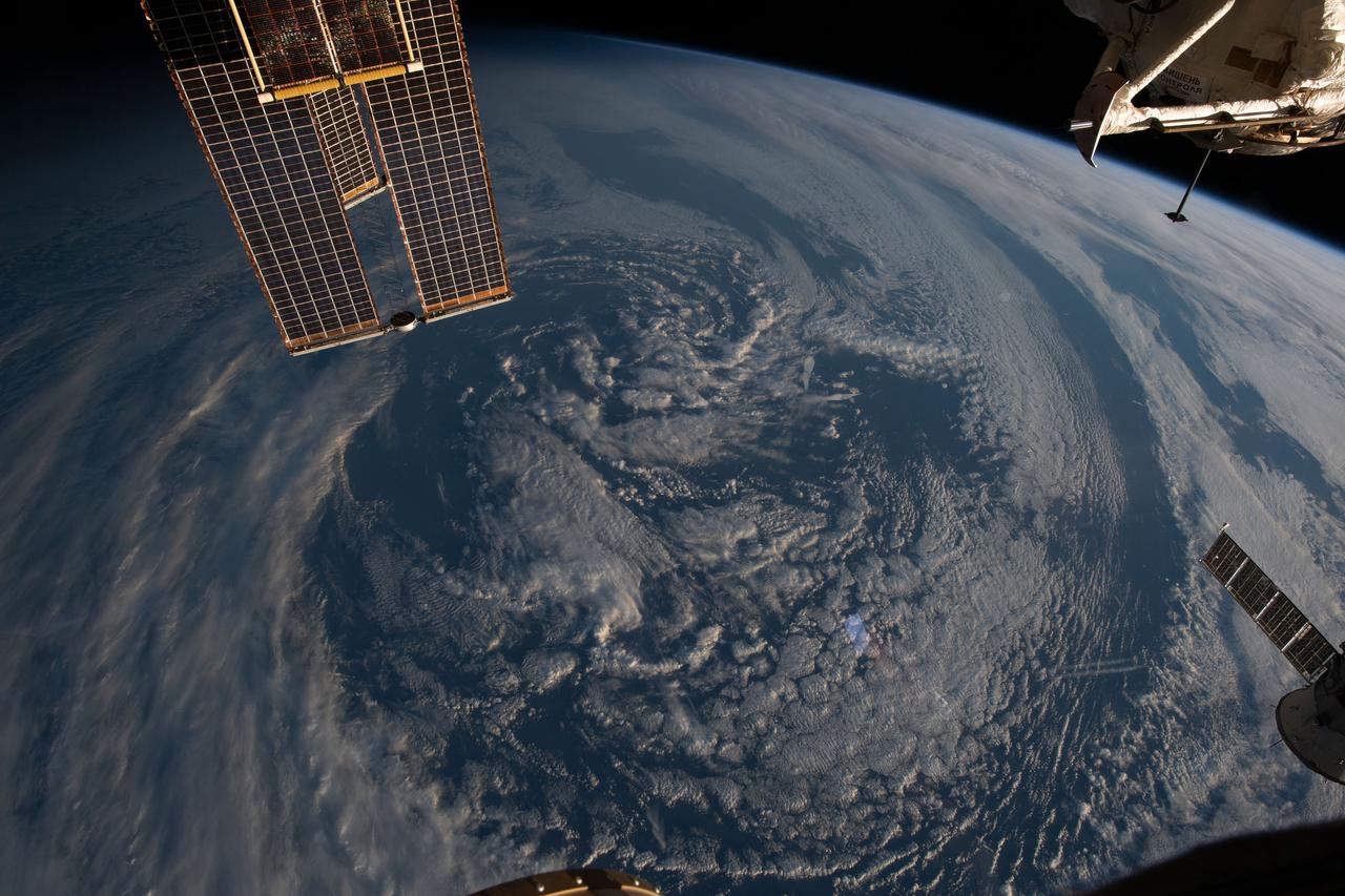 iss069e027354 (July 2, 2023) -- Clouds cover Earth and the orbital lab's solar arrays are shown in the top left corner as the space station orbits 270 miles above the Atlantic Ocean off the coast of Argentina.