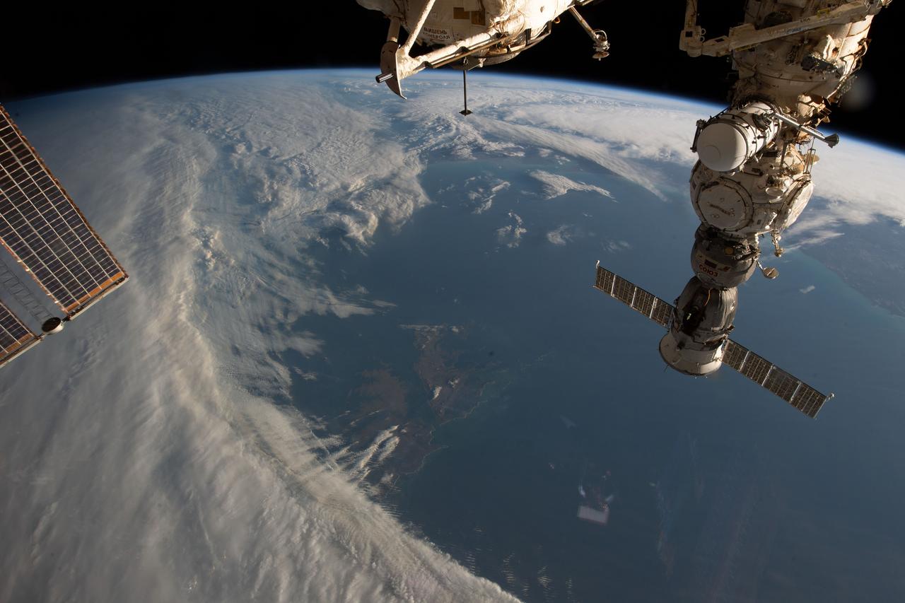 iss069e027359 (July 2, 2023) -- A set of remote South Atlantic islands, the Falkland Islands, peek through the clouds as the space station orbits 270 miles above Earth off the coast of South America. The Russian segment of the International Space Station can be seen to the right of the image, while a pair of solar arrays are partially shown on the left.
