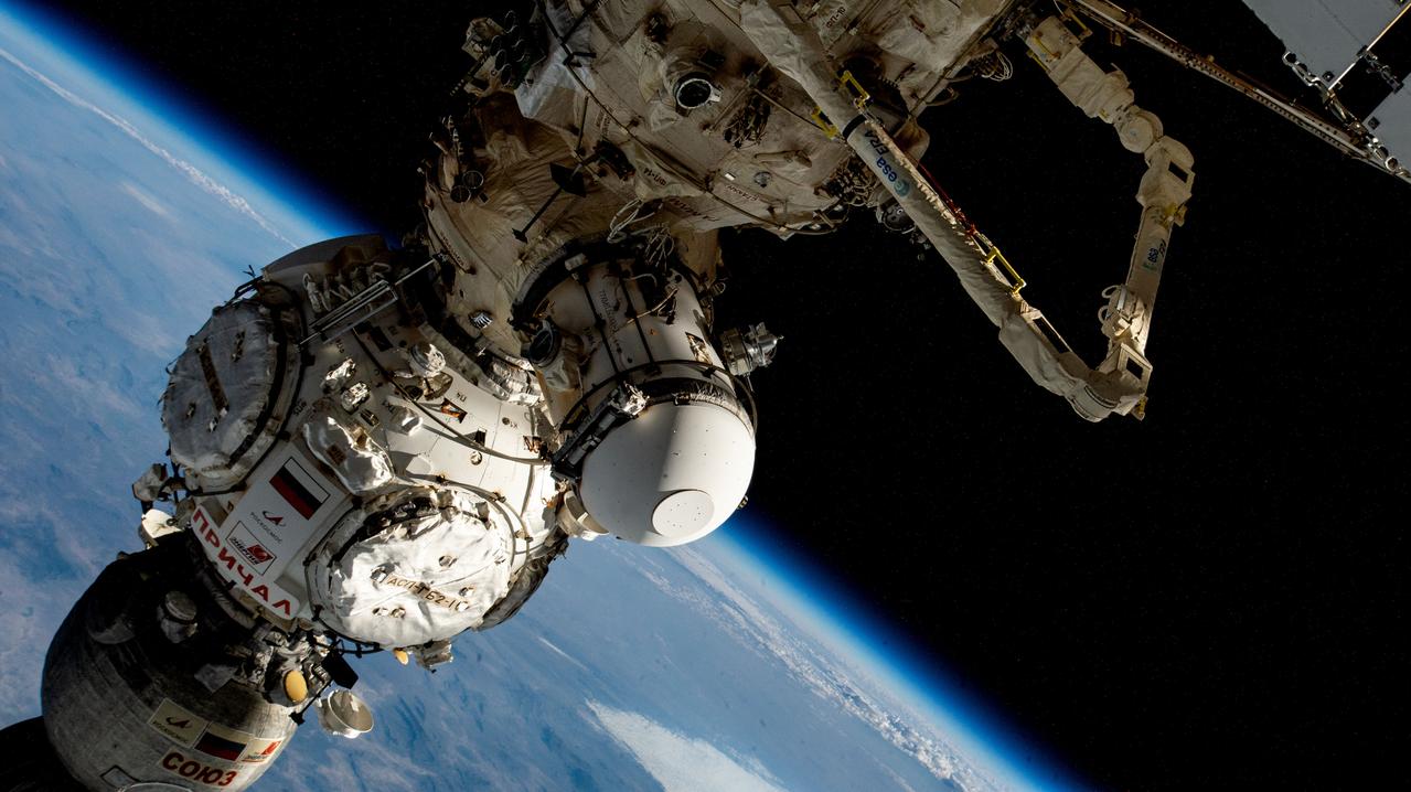 iss069e030000 (July 7, 2023) --- From top to bottom, the Soyuz MS-23 crew ship is docked to the Prichal docking module, which is attached to the Nauka multipurpose laboratory module. Other elements pictured, include the European robotic arm extending out from Nauka and an experiment airlock attached to a port on Nauka.