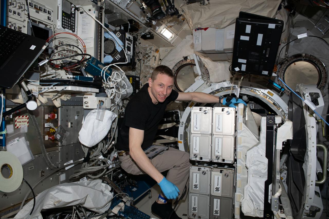 iss069e030663 (July 10, 2023) --- NASA astronaut and Expedition 69 Flight Engineer Woody Hoburg removes the NanoRacks CubeSat Deployer from the Kibo laboratory module's airlock.