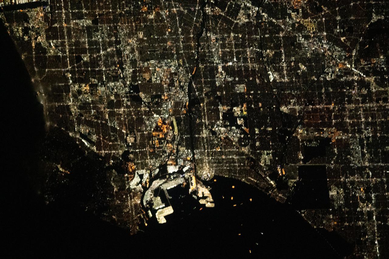 iss069e032998 (July 19, 2023) --- The city lights of Los Angeles, California, and its surrounding suburbs, are pictured from the International Space Station as it orbited 261 miles above. Terminal Island, an artificial island containing the ports of Los Angeles and Long Beach, is featured prominently at the bottom center of this photograph.