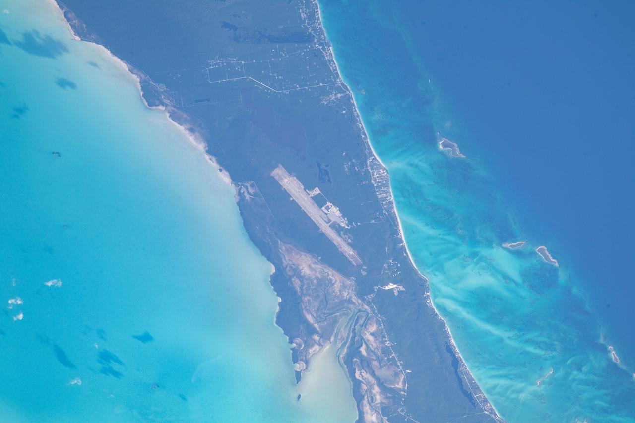 ss069e033721 (July 17, 2023) -- The Great Exuma, an island in the Bahamas, is pictured from the International Space Station as it soared 259 miles above. The bright teal water of the Atlantic Ocean can be seen surrounding the island, while the Exuma International Airport is seen near the center of the land.