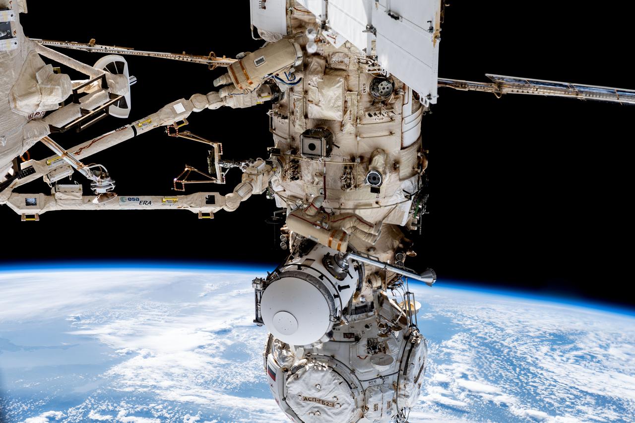 iss069e056478 (Aug. 9, 2023) --- Expedition 69 crew members Dmitri Petelin (top) and Sergey Prokopyev (center), both from Roscosmos, are pictured in their Orlan spacesuits during a six-hour and 35-minute spacewalk to install orbital debris shields and relocate a portable workstation on the International Space Station. The European robotic arm extends from the Nauka science module to which the Prichal module and the Soyuz MS-23 crew ship are attached.