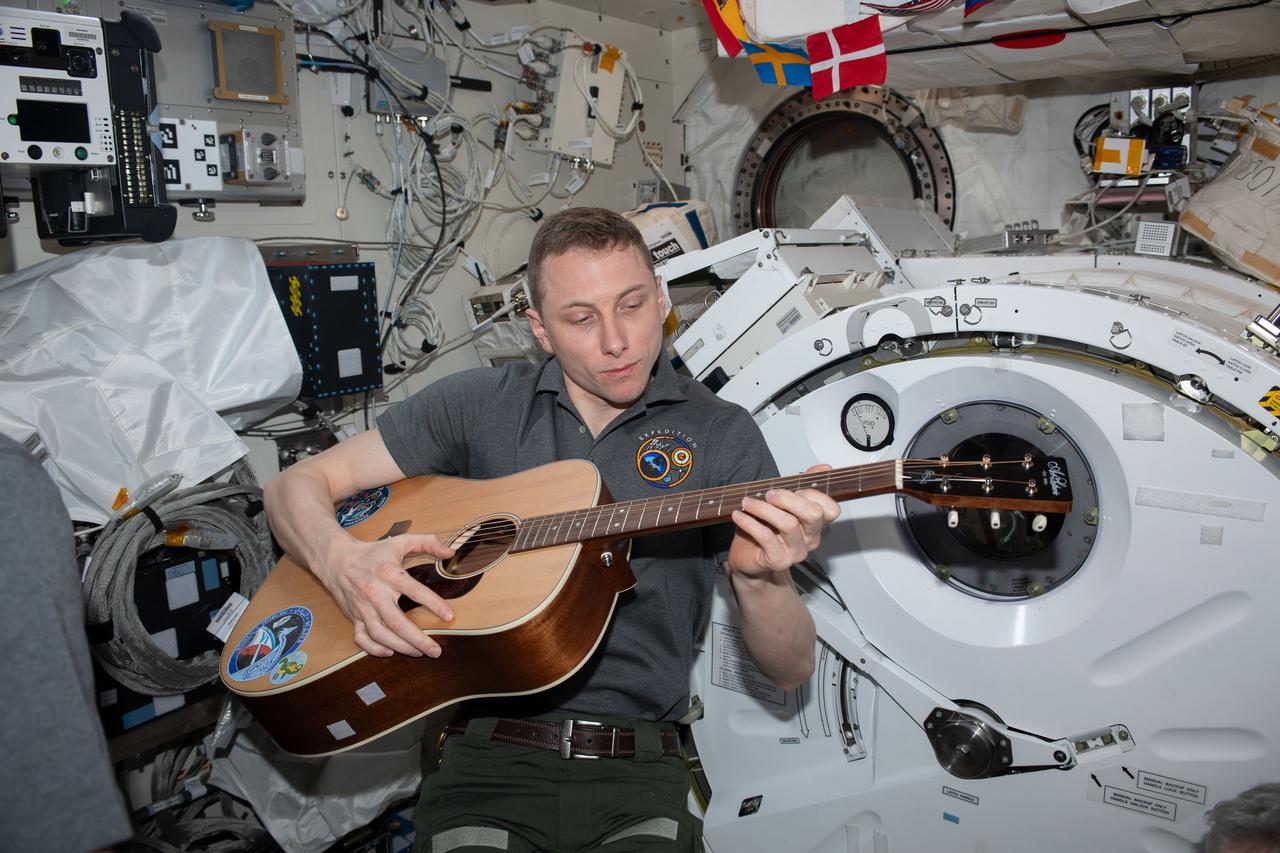 iss069e071239 (Aug. 20, 2023) --- NASA astronaut and Expedition 69 Flight Engineer Woody Hoburg relaxes and plays guitar inside the International Space Station's Kibo laboratory module.