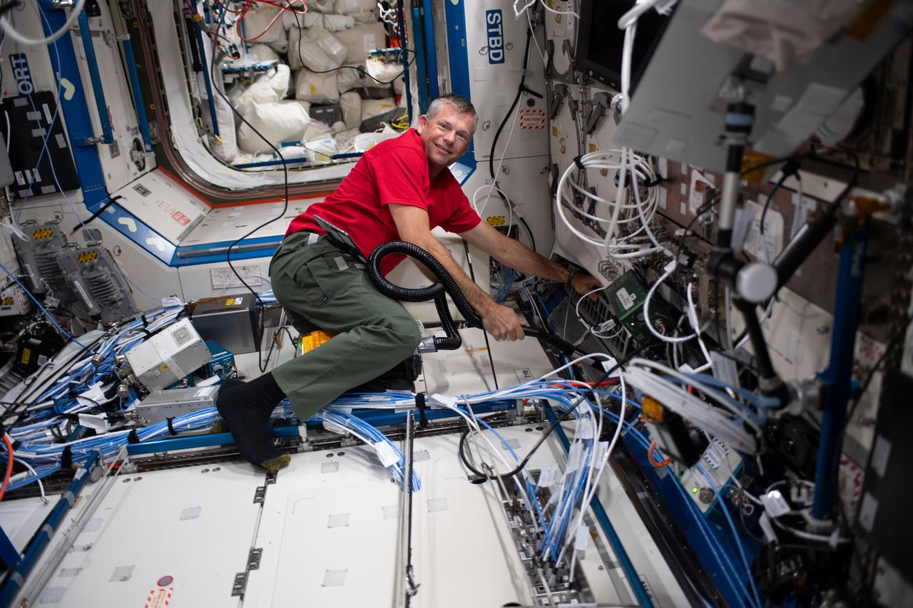 iss069e086350 (Sept. 9, 2023) --- ESA (European Space Agency) and Expedition 69 Flight Engineer Andreas Mogensen uses a vacuum cleaner to clean fans, filters, and ventilation systems aboard the International Space Station.