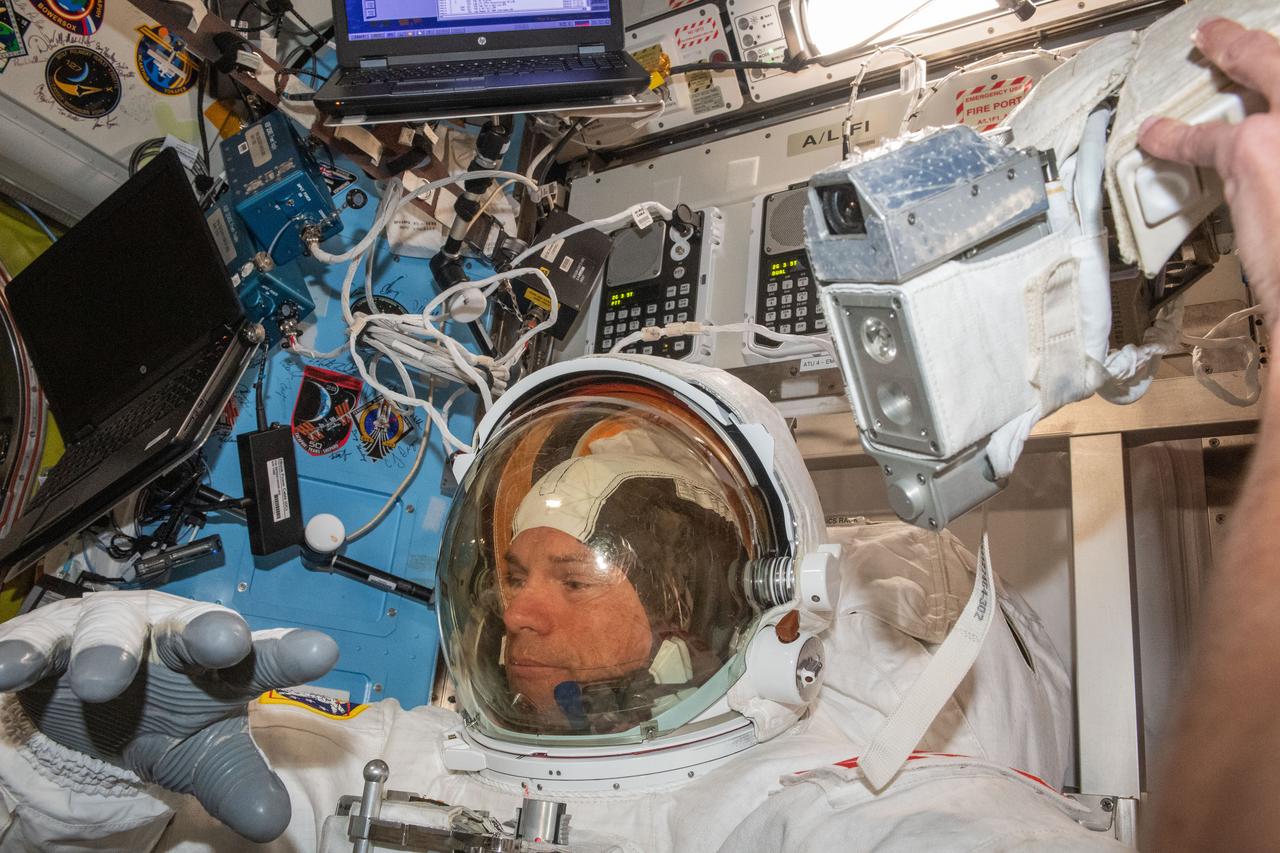 iss070e002031 (Oct. 4, 2023) --- ESA (European Space Agency) astronaut and Expedition 70 Commander Andreas Mogensen is pictured trying on his spacesuit and testing its components aboard the International Space Station's Quest airlock in preparation for an upcoming spacewalk.