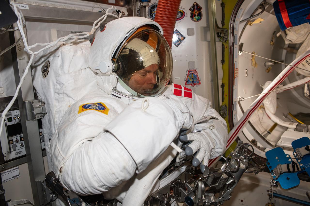 iss070e002033 (Oct. 4, 2023) --- ESA (European Space Agency) astronaut and Expedition 70 Commander Andreas Mogensen is pictured trying on his spacesuit and testing its components aboard the International Space Station's Quest airlock in preparation for an upcoming spacewalk.