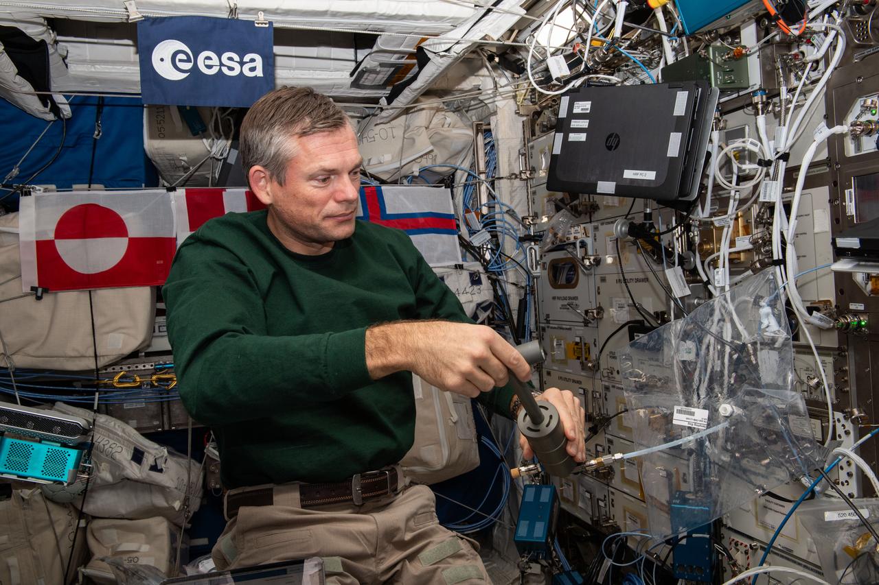 iss070e003120_alt (10/12/2023) ---  European Space Agency (ESA) astronaut Andreas Mogensen is seen filling an ANITA-2 sampling bag a measurement demonstration. The ANITA-2 is a compact gas analyzer which can analyze and quantify 33 trace contaminants in the atmosphere aboard the ISS automatically.
