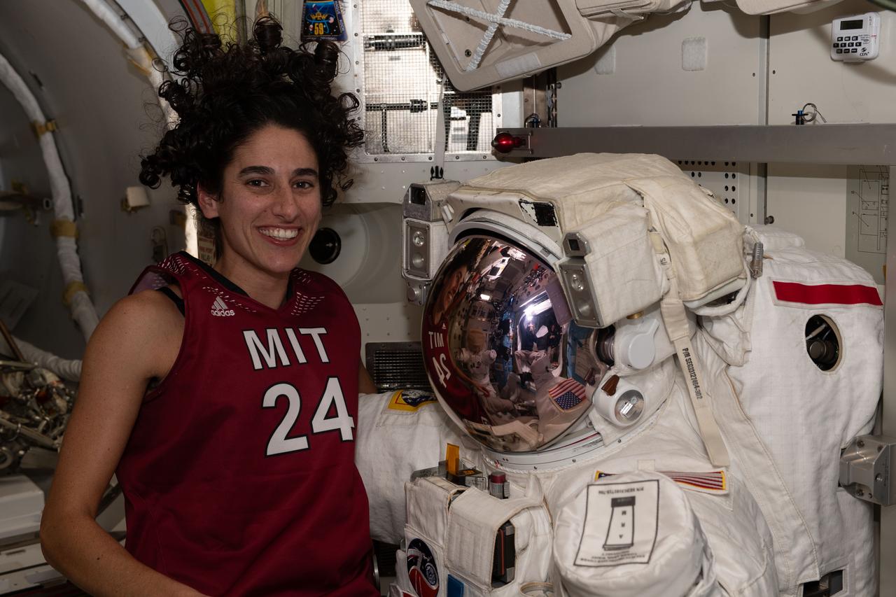 iss070e020913 (Nov. 3, 2023) --- NASA astronaut and Expedition 70 Flight Engineer Jasmin Moghbeli poses with a spacesuit in the International Space Station's Quest airlock.