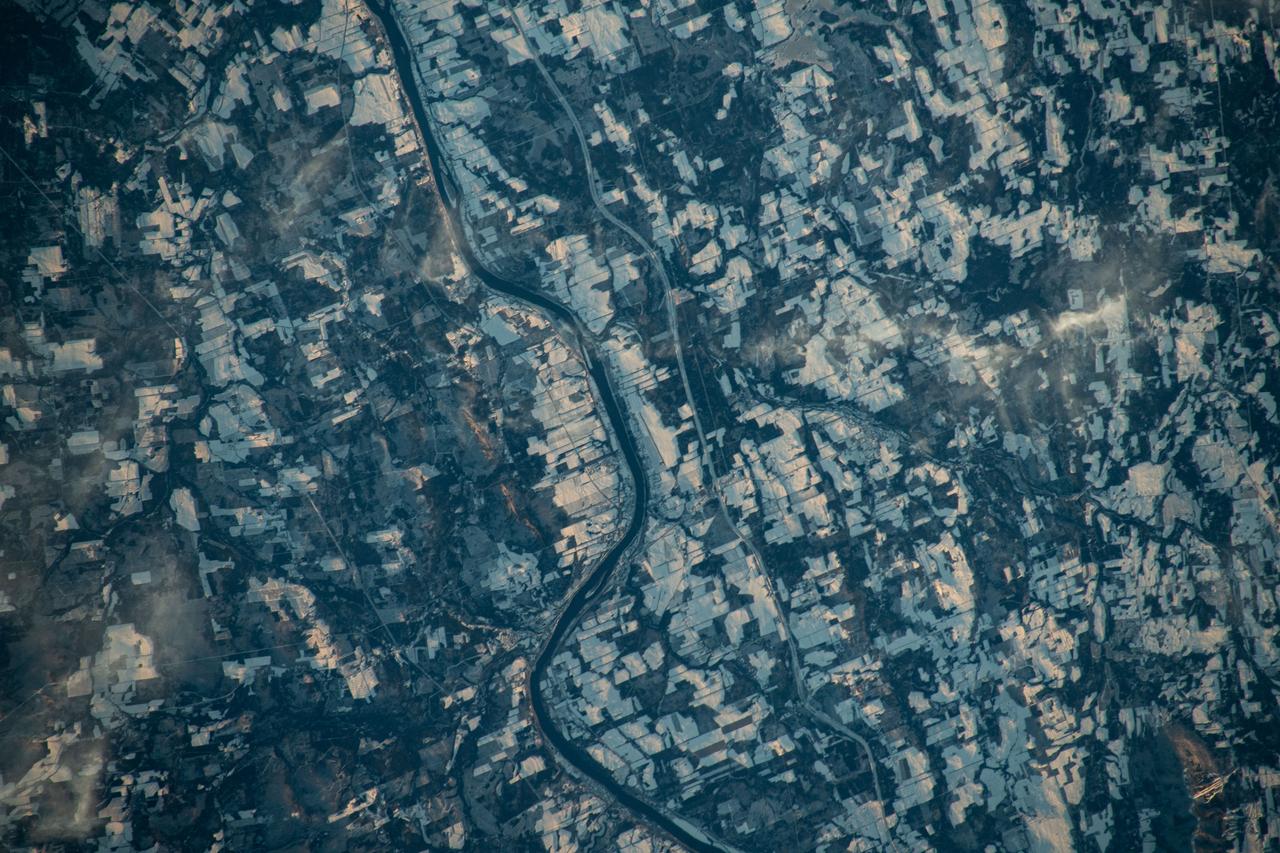 iss070e031278 (Nov. 25, 2023) --- The Canadian town of Carleton North, split by the St John River in the province of New Brunswick, borders Maine in the United States. The blue-gray colors of the landscape reveal the frigid temperatures in far North America in this photograph from the International Space Station as it orbited 262 miles above