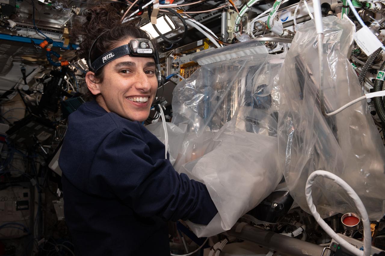 iss070e035114 (Dec. 1, 2023) --- NASA astronaut and Expedition 70 Flight Engineer Jasmin Moghbeli uses a portable glovebag and removes a tissue cassette containing printed cardiac tissue samples from the BioFabrication Facility that is demonstrating printing organ-like tissues in microgravity. The cassette was then installed into an advanced sample processor that can be configured for a variety of biological and physics investigations.