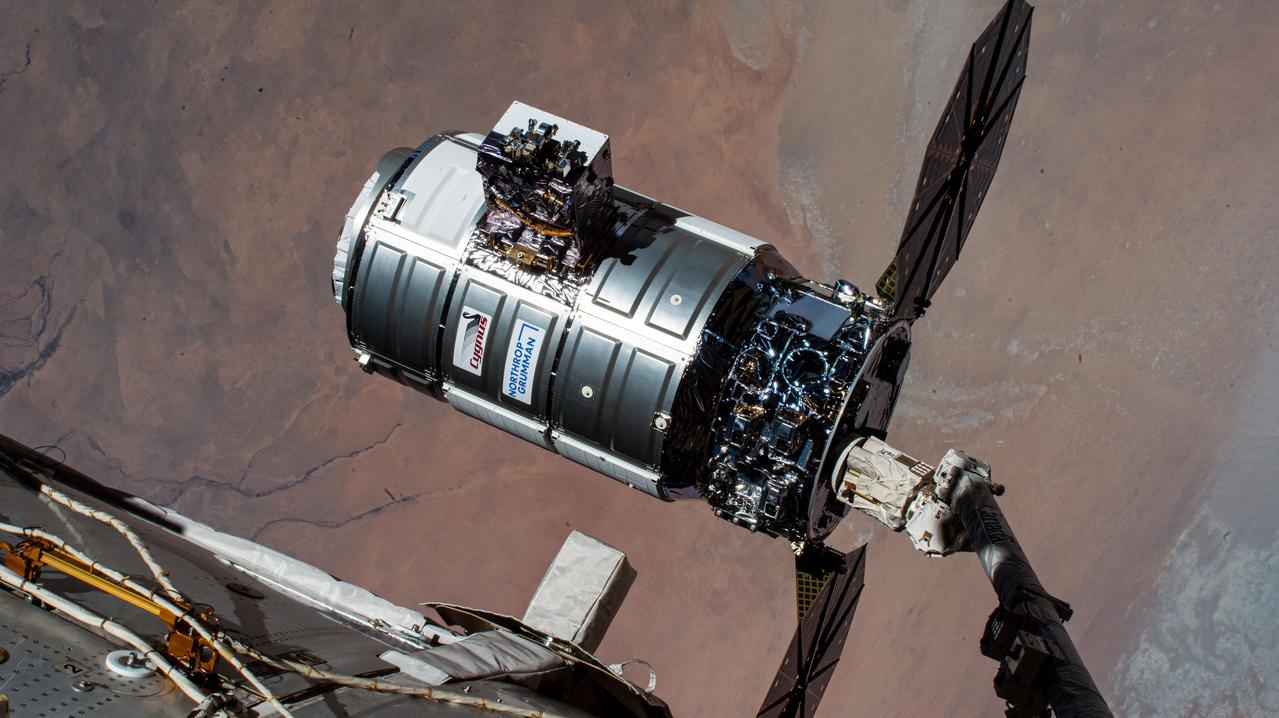 iss070e044171 (Dec. 22, 2023) --- Northrop Grumman's Cygnus space freighter is pictured in the grip of the Canadarm2 robotic arm moments before its release. The orbital complex was soaring 258 miles above the African nation of Chad at the time of this photograph.