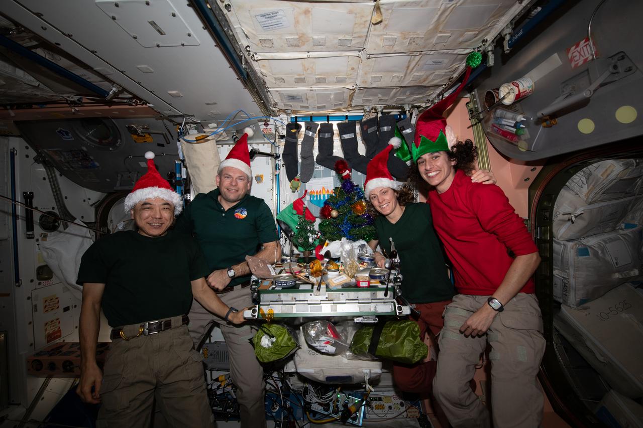 iss070e044842 (Dec. 25, 2023) --- Four Expedition 70 crewmates join each other inside the International Space Station's Unity module for a Christmas Day meal. From left are, Flight Engineer Koichi Wakata from JAXA (Japan Aerospace Exploration Agency); Commander Andreas Mogensen from ESA (European Space Agency); and NASA Flight Engineers Loral O'Hara and Jasmin Moghbeli.