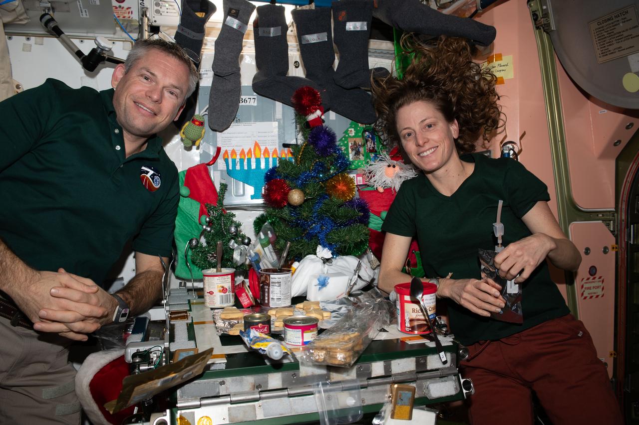 iss070e045128 (Dec. 24, 2023) --- Expedition 70 Commander Andreas Mogensen from ESA (European Space Agency) and NASA Flight Engineer Loral O'Hara are pictured inside the International Space Station's Unity module enjoying a Christmas Day meal.