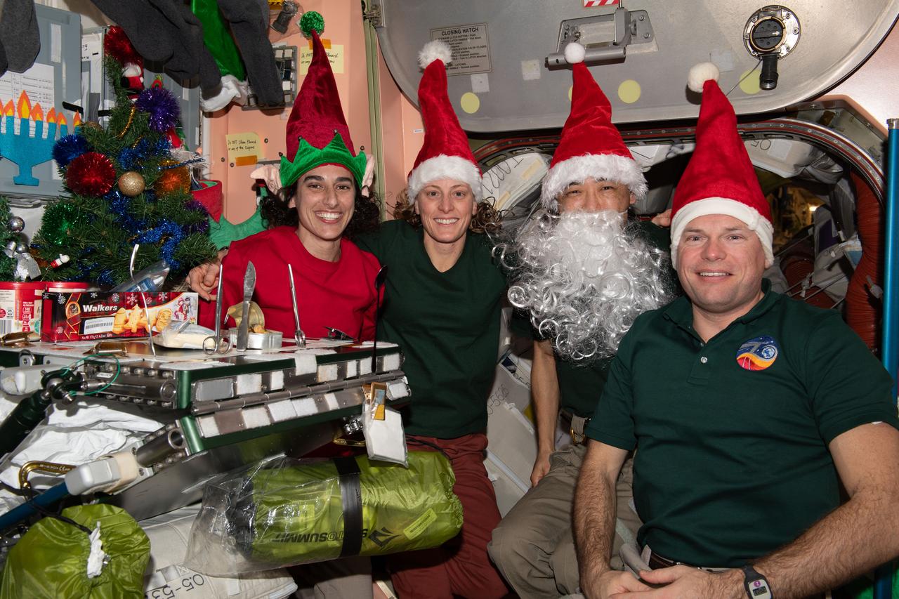 iss070e045419 (Dec. 24, 2023) --- Four Expedition 70 crewmates join each other inside the International Space Station's Unity module for Christmas Eve festivities. From left are, NASA Flight Engineers Jasmin Moghbeli and Loral O'Hara; Flight Engineer Koichi Wakata from JAXA (Japan Aerospace Exploration Agency); and Commander Andreas Mogensen from ESA (European Space Agency).