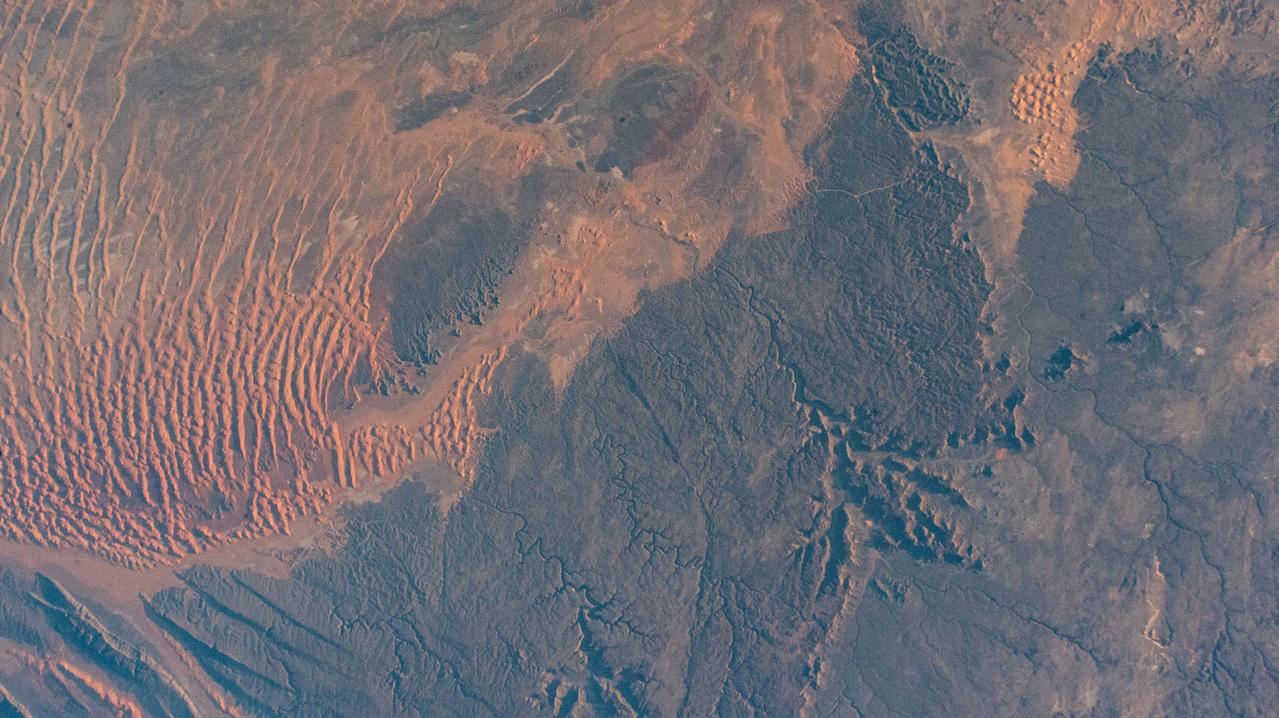 iss070e052305 (Jan. 3, 2024) --- Sand dunes, sandstone plateaus, and rocky platforms that comprise the Tassili N'Ajjer National Park in the southeastern portion of Algeria are pictured from the International Space Station as it orbited 261 mile above the Sahara.