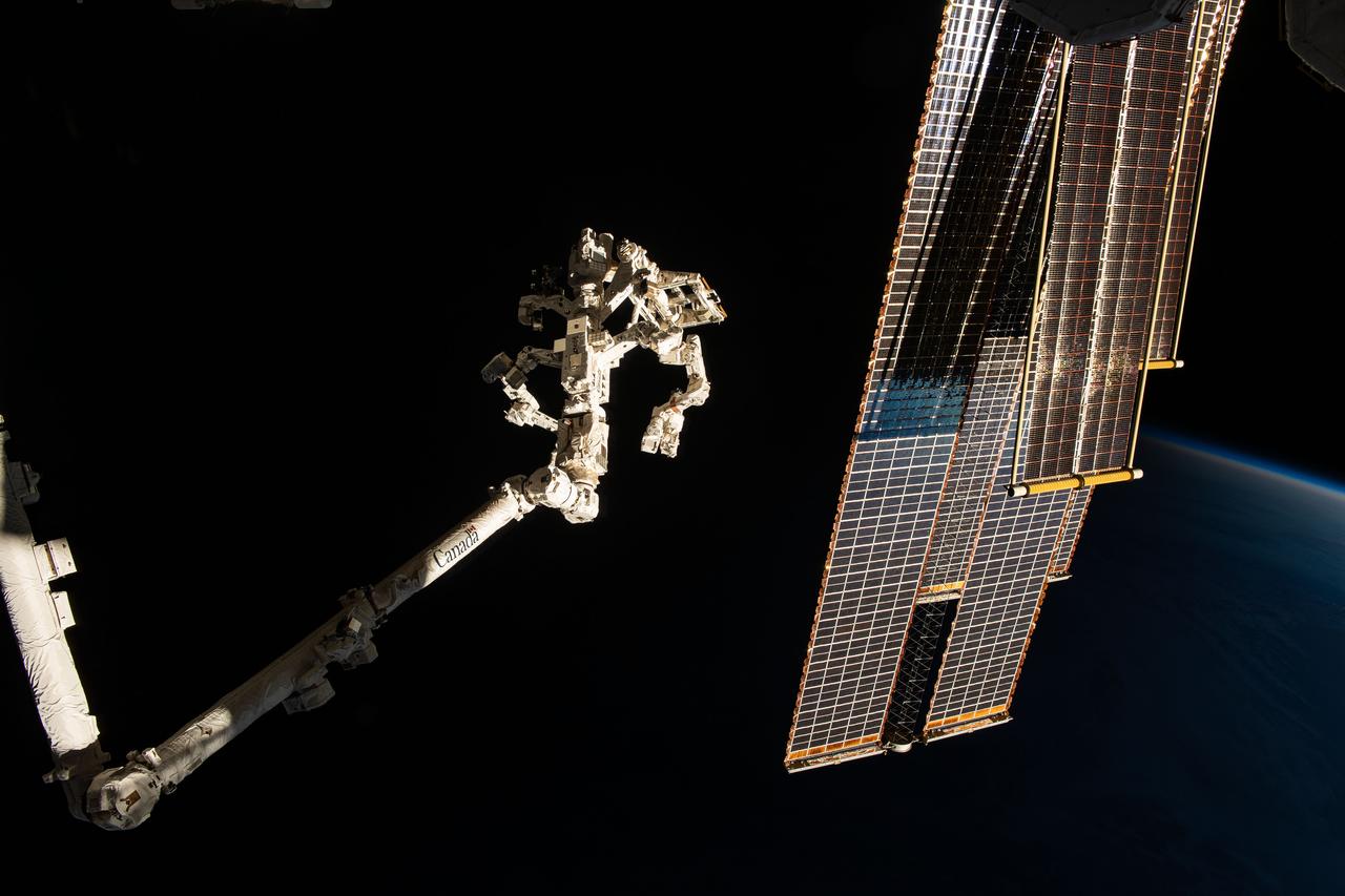 iss070e076757 (Jan. 22, 2024) --- The Earth's horizon is barely visible as the International Space Station soars into an orbital sunset 261 miles above northeastern China. In the foreground, are the Canadarm2 robotic arm (left) with the Dextre fine-tuned robotic hand attached and the orbital outpost's main solar arrays (right) and shorter roll-out solar arrays.
