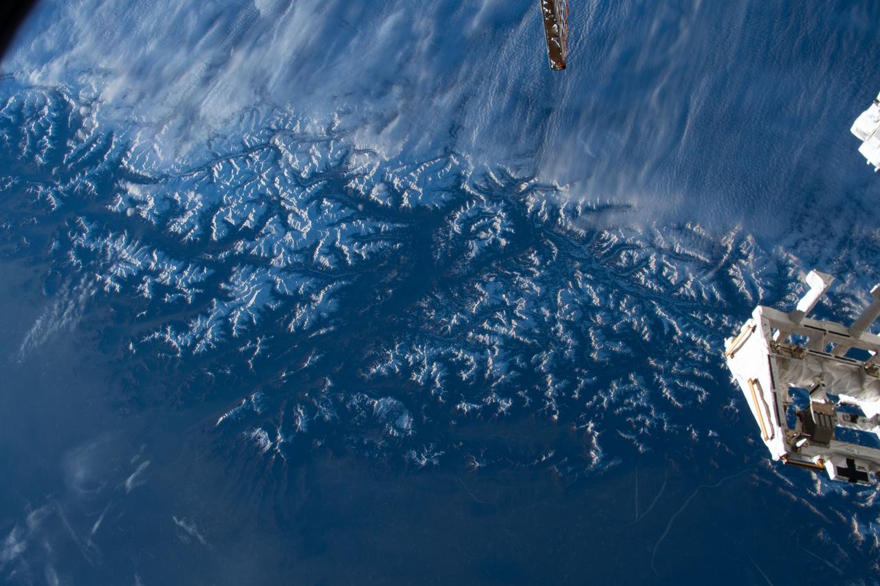 iss070e080294 (Jan. 23, 2024) --- Clouds stop on the peaks of the snow-capped Alps that separate Italy's Po Valley from Austria in this photograph from the International Space Station as it orbited 261 miles above.