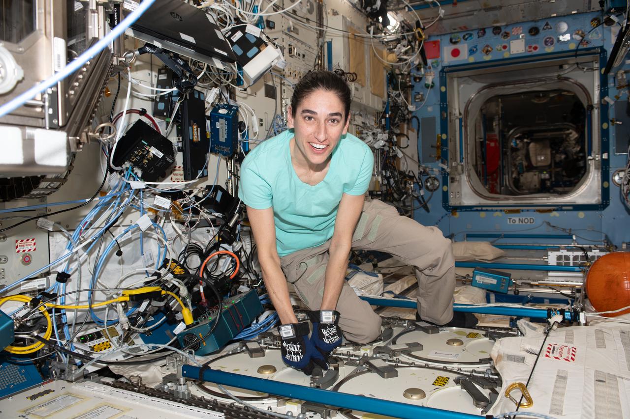 iss070e091765 (Feb. 12, 2024) --- NASA astronaut and Expedition 70 Flight Engineer Jasmin Moghbeli is pictured inside the International Space Station's Destiny laboratory module opening a science freezer that hosts research samples for preservation and analysis.