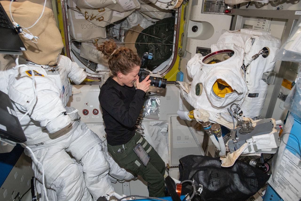 iss070e123815 (March 13, 2024) --- Expedition 70 Flight Engineer and NASA astronaut Loral O'Hara photographs the condition of spacesuits during maintenance inside the International Space Station's Quest airlock.