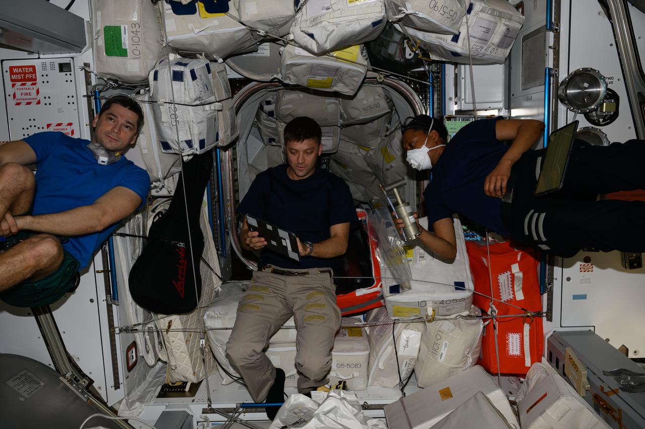 iss070e128597 (March 23, 2024) --- Expeditiom 70 Flight Engineers (from left) Nikolai Chub from Roscosmos, Matthew Dominick and Jeanette Epps, both from NASA, are pictured inside the International Space Station's Harmony module. The trio was awaiting the opening of the SpaceX Dragon cargo craft's hatch on Harmony's space-facing port.