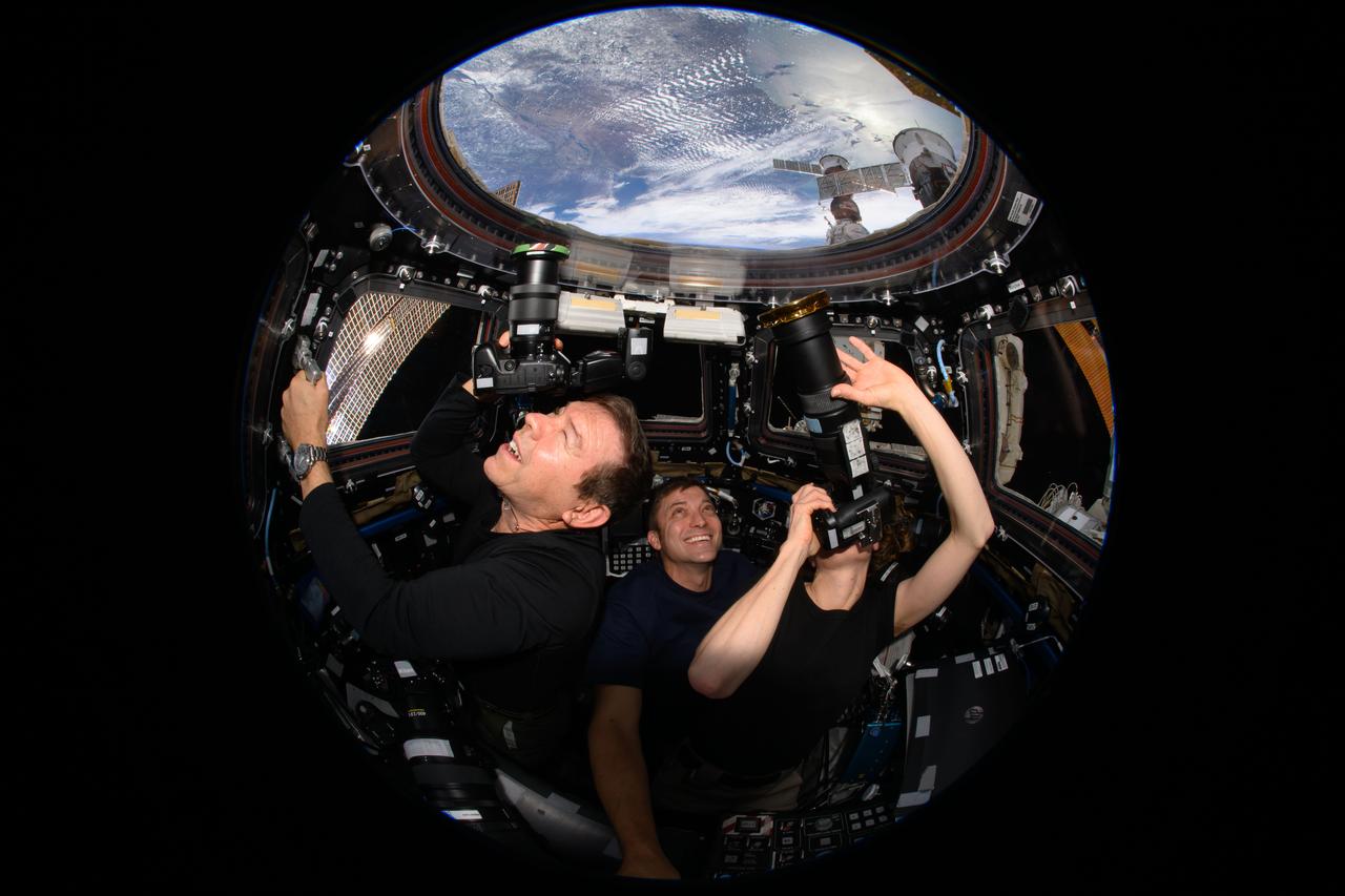 iss070e132878 (March 31, 2024) --- Expedition 70 Flight Engineers (from left) Mike Barratt, Matthew Dominick, and Loral O'Hara participate in an Earth photography session inside the cupola, the International Space Station's "window to the world." The orbital complex was soaring 259 miles above West Virginia in the United States at the time of this photograph.