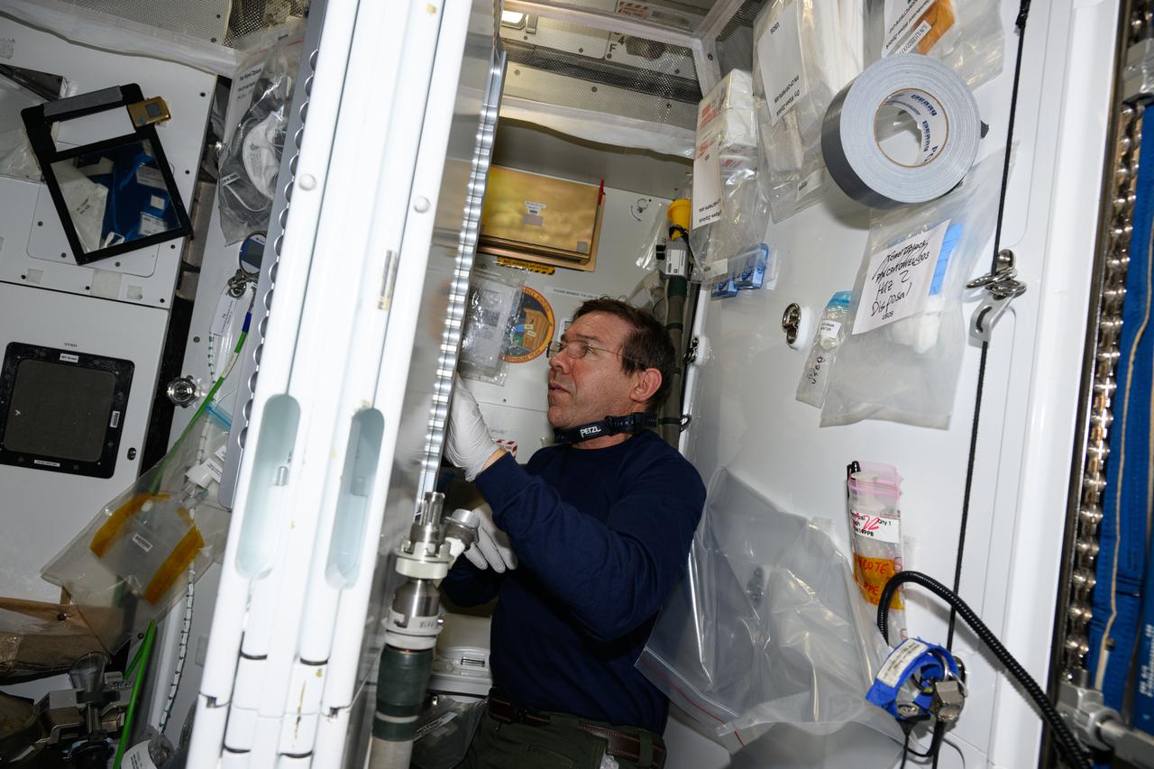 iss071e000964 (April 6, 2024) --- Expedition 71 Flight Engineer and NASA astronaut Mike Barratt works on orbital plumbing duties inside the Waste and Hygiene Compartment, the International Space Station's bathroom located aboard the Tranquility module.